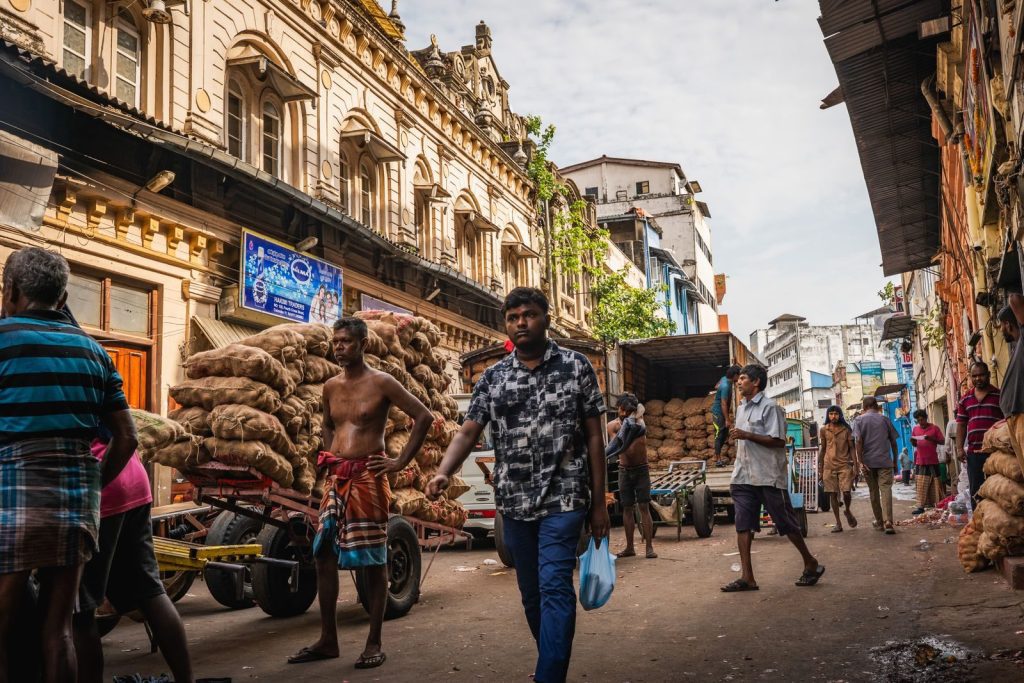 Vibrant scene of Pettah market in Colombo with people and goods in a lively street setting.