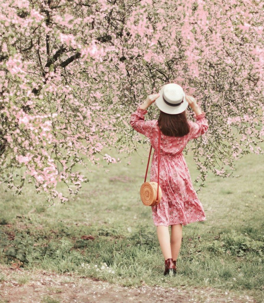 Woman in floral dress under blooming trees