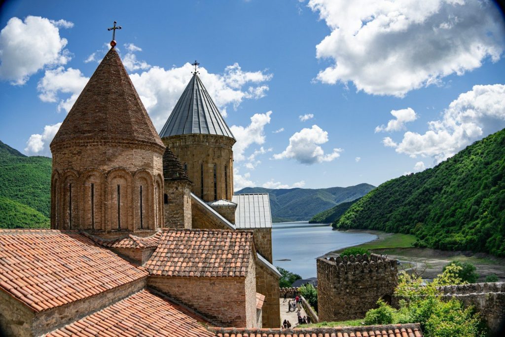 a view of a church with a lake in the background