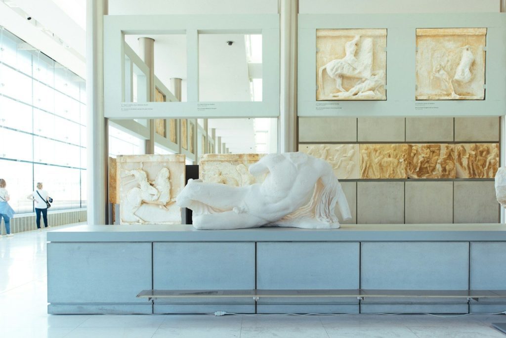 a white sculpture of a person lying on a bench
