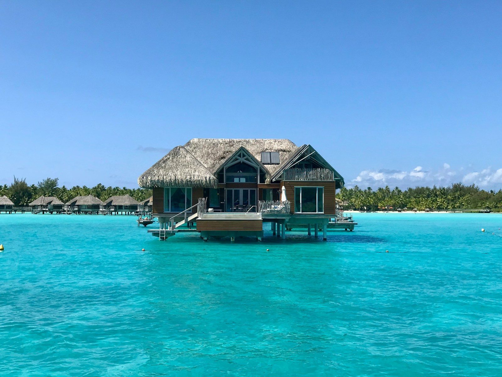 a house on stilts in the middle of the ocean